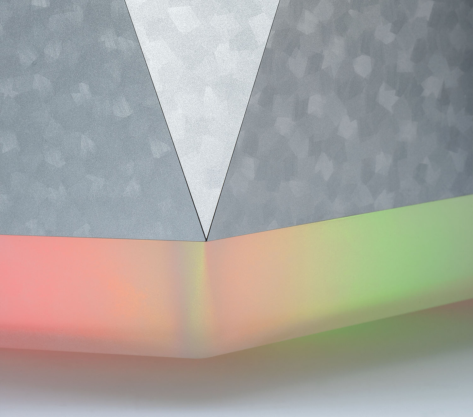 Zoom auf Ecke des pyramidenförmigen Rechners mit hinterleuchtetem Boden und metallisiertem Corpus